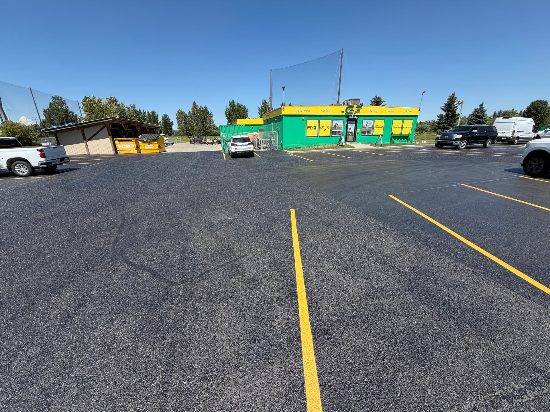 Retail parking lot in Calgary with fresh black sealcoat and bright yellow stall lines