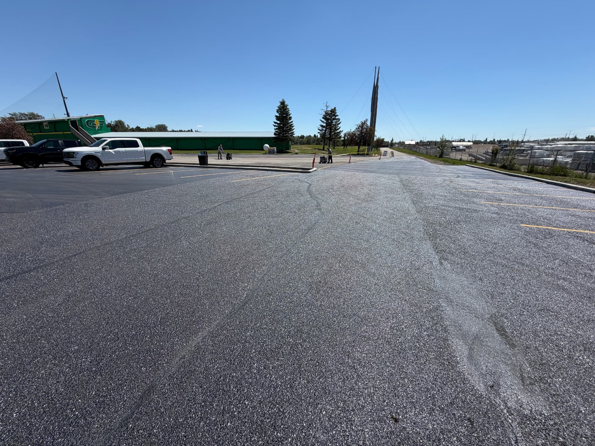 Large freshly sealed industrial asphalt yard in Calgary under clear sky