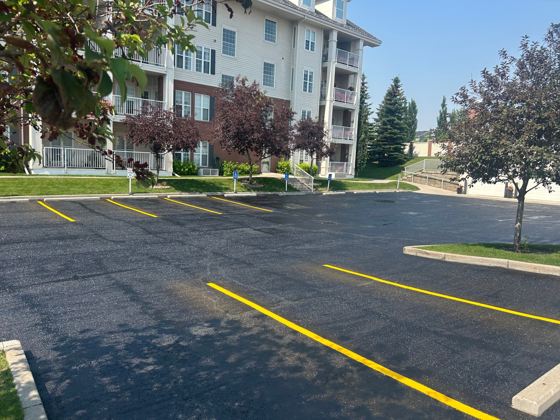 Freshly sealed campus parking lot in Calgary with crisp new yellow stall lines