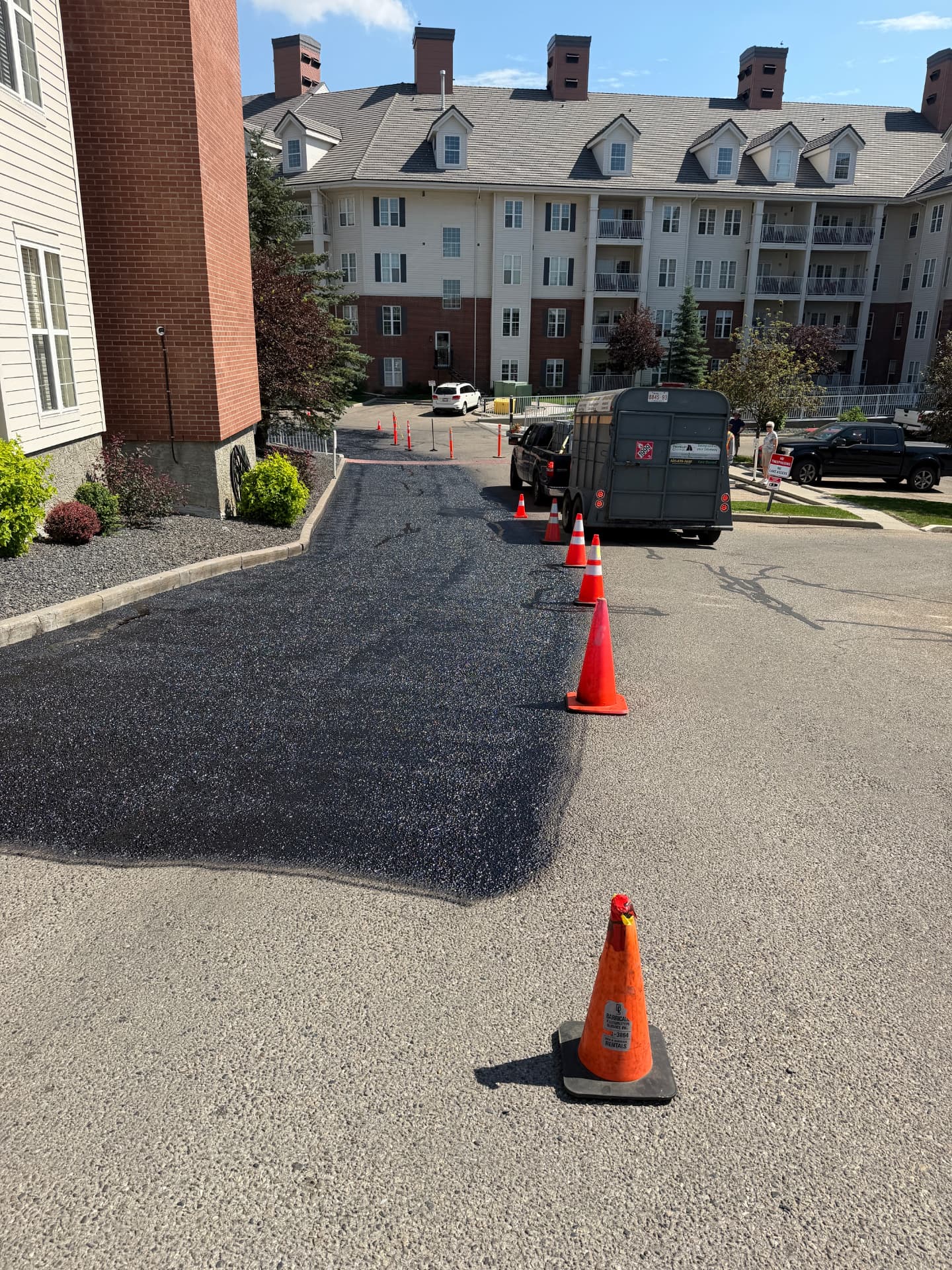 Freshly paved condominium parking area in Calgary marked off with orange cones