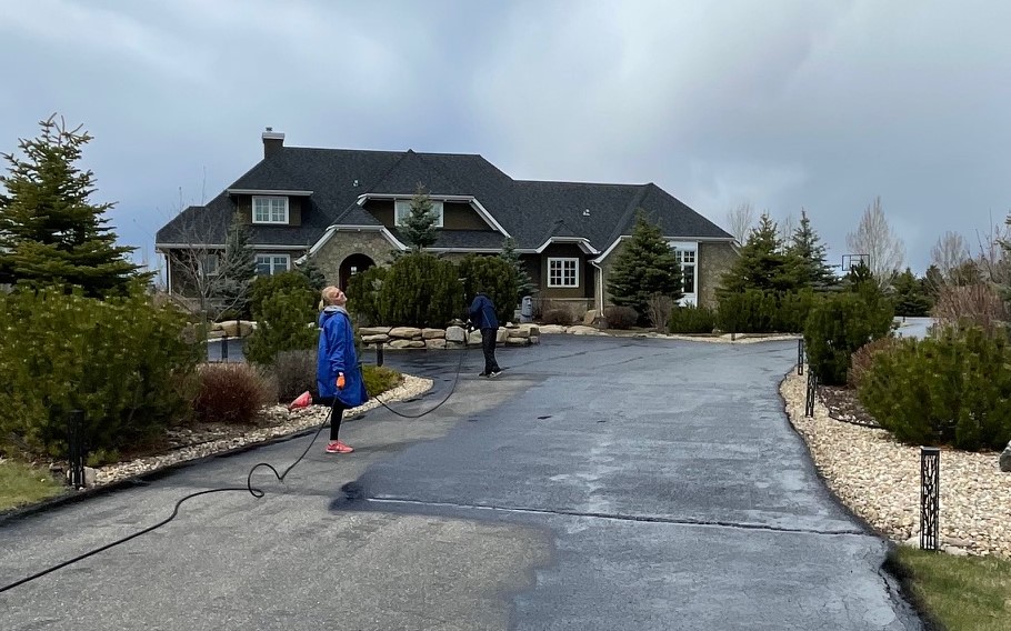 Driveway mid-application with sealer being squeegeed across the surface